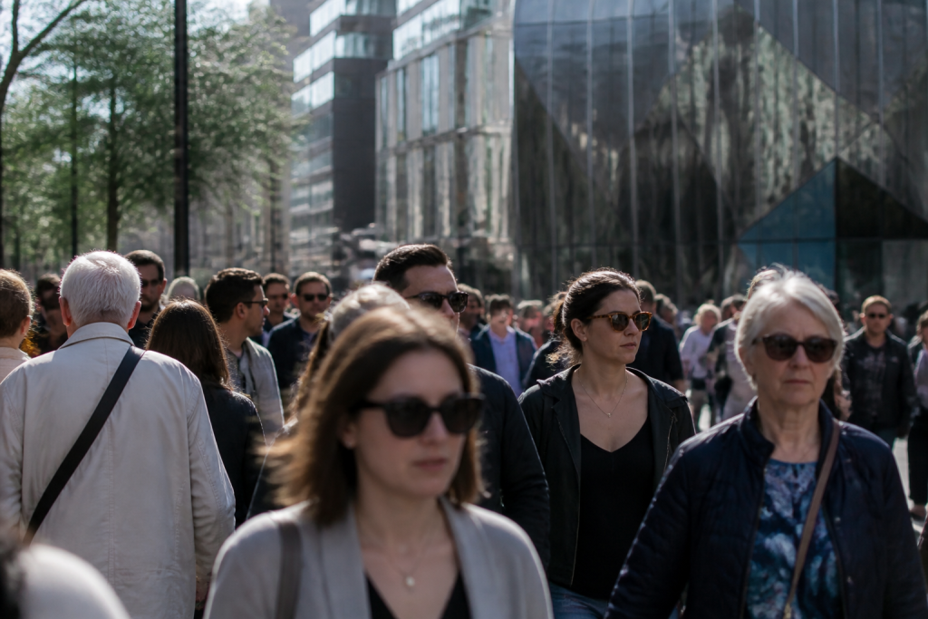 Foule de passants devant des immeubles scintillants