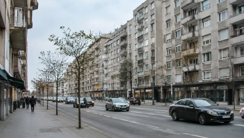 Grands immeubles gris alignés le long d'une avenue passante