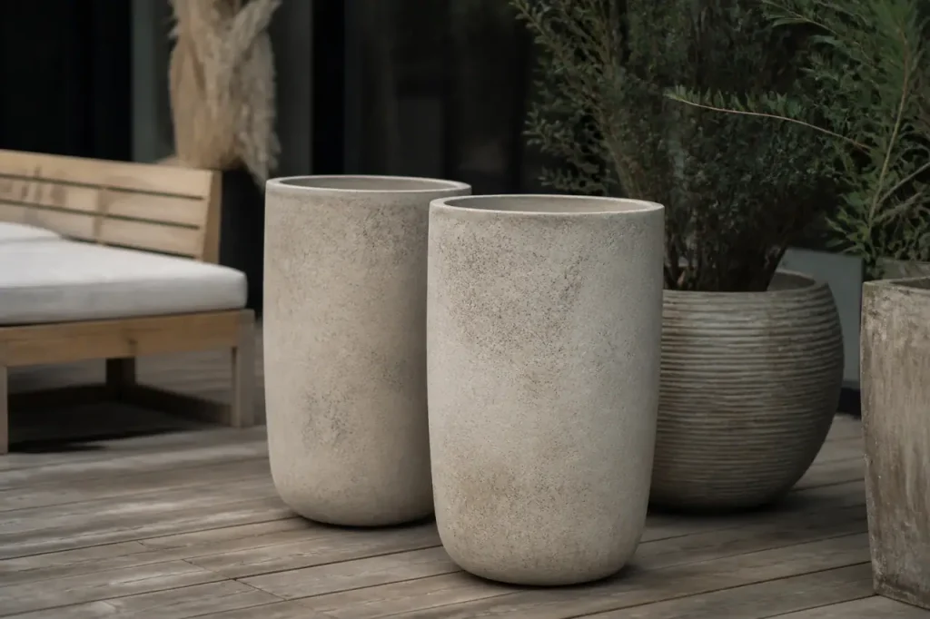 Grands vases clairs effet pierre sur terrasse en bois