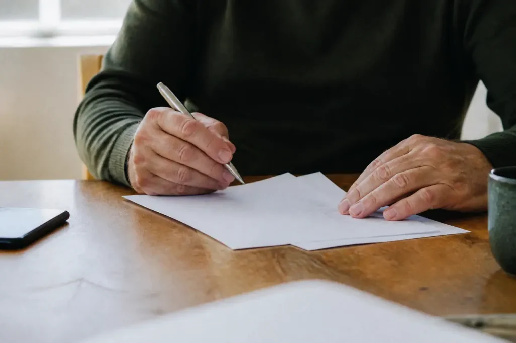 Main tenant un stylo sur deux devis imprimes