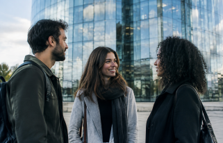 Trois personnes debout devant une tour vitree scintillante