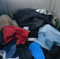 Pile de habits deposes dans conteneur gris