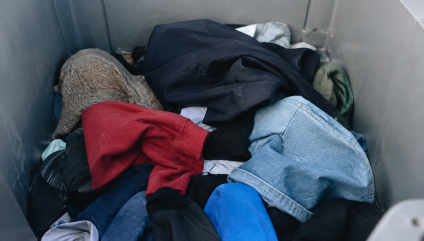 Pile de habits deposes dans conteneur gris