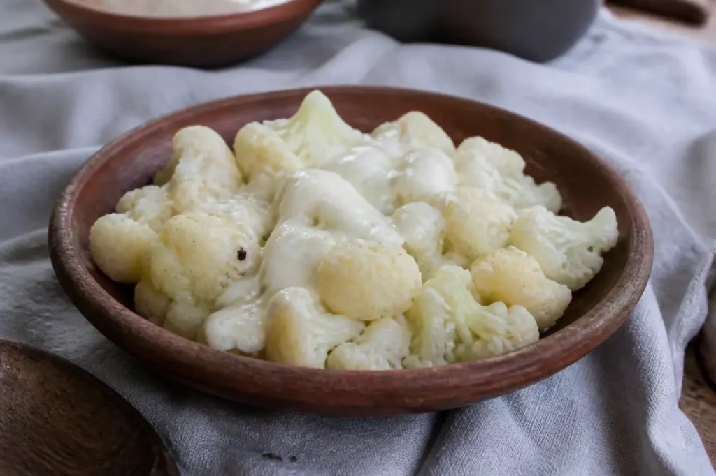 Plat en terre cuite avec chou-fleur et sauce blanche