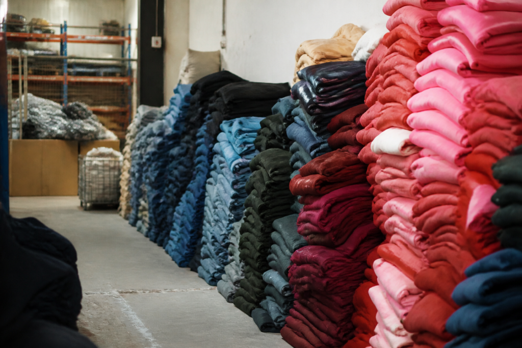 Tas de vetements empiles par couleur en entrepot